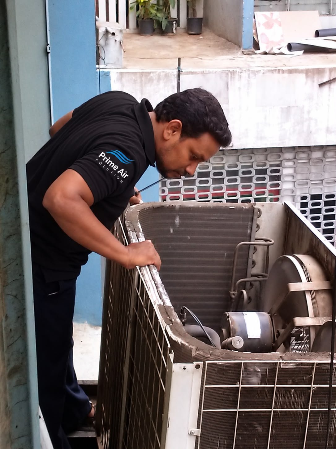 Shaik Afsar inspecting an outdoor AC condenser unit on site in Hyderabad
